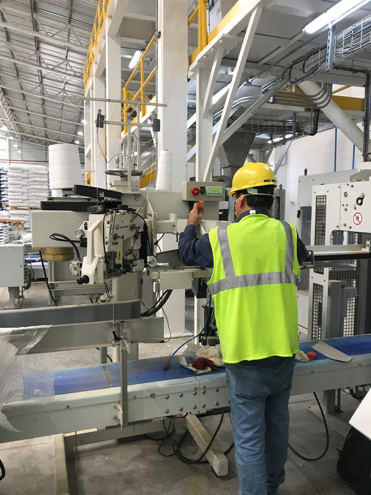 Técnico Lovatech realizando servicio a cosedora industrial en línea de ensacado